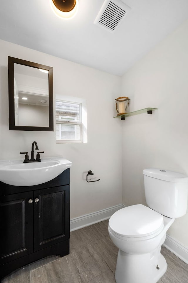 bathroom featuring hardwood / wood-style floors, vanity, and toilet