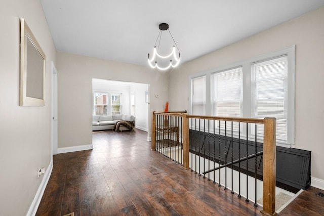 hall featuring a notable chandelier and dark hardwood / wood-style flooring