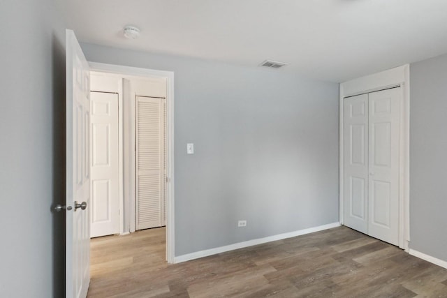 unfurnished bedroom with a closet and light hardwood / wood-style flooring