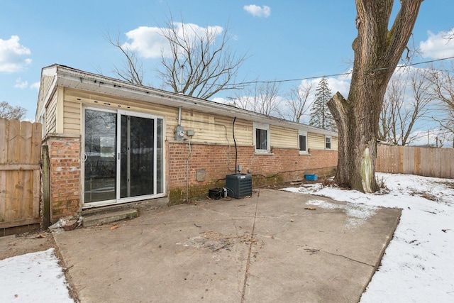 snow covered property featuring a patio and central air condition unit