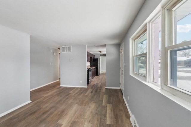 unfurnished living room featuring dark hardwood / wood-style floors and a wealth of natural light