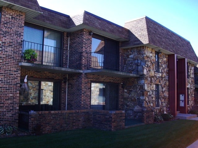 view of side of property with a yard and a balcony