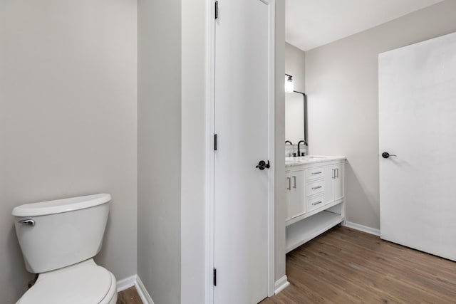 bathroom featuring hardwood / wood-style flooring, toilet, and vanity