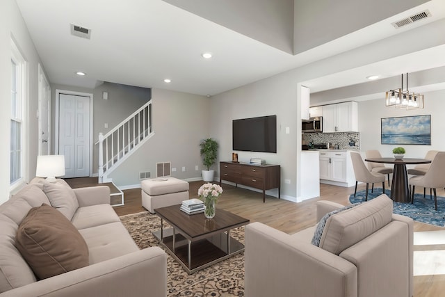 living room featuring light hardwood / wood-style flooring and an inviting chandelier