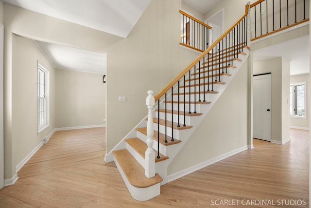 stairway with wood finished floors and baseboards