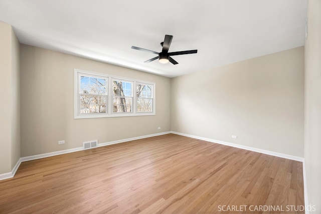 spare room with a ceiling fan, baseboards, visible vents, and light wood finished floors