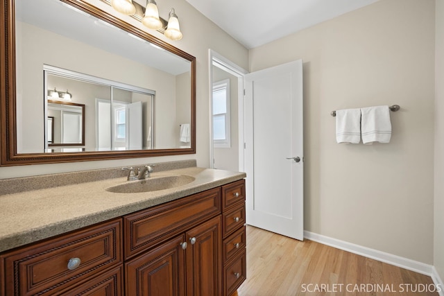 bathroom featuring vanity, baseboards, and wood finished floors