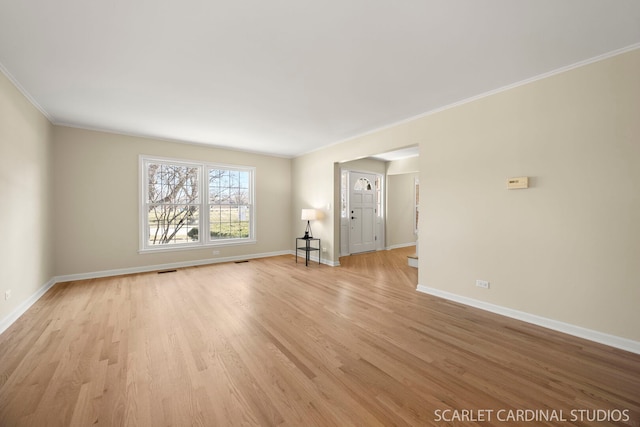 unfurnished living room with light wood-style floors, baseboards, and ornamental molding