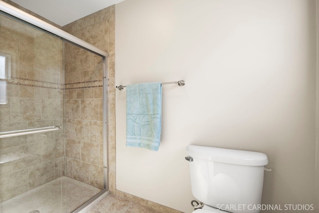 bathroom featuring a shower stall and toilet