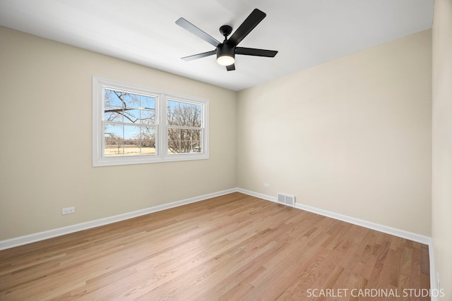 spare room featuring visible vents, ceiling fan, light wood-type flooring, and baseboards