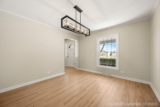 unfurnished dining area with visible vents, crown molding, baseboards, light wood-style flooring, and a notable chandelier