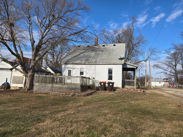 back of house with a lawn and a deck