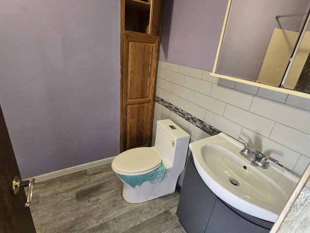 bathroom with wood-type flooring, toilet, tile walls, and sink