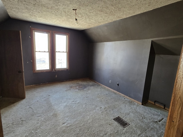 bonus room featuring light carpet, a textured ceiling, and vaulted ceiling