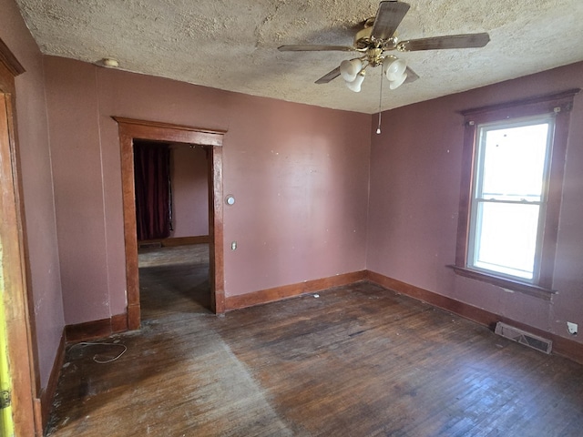 empty room featuring a textured ceiling, ceiling fan, and dark wood-type flooring