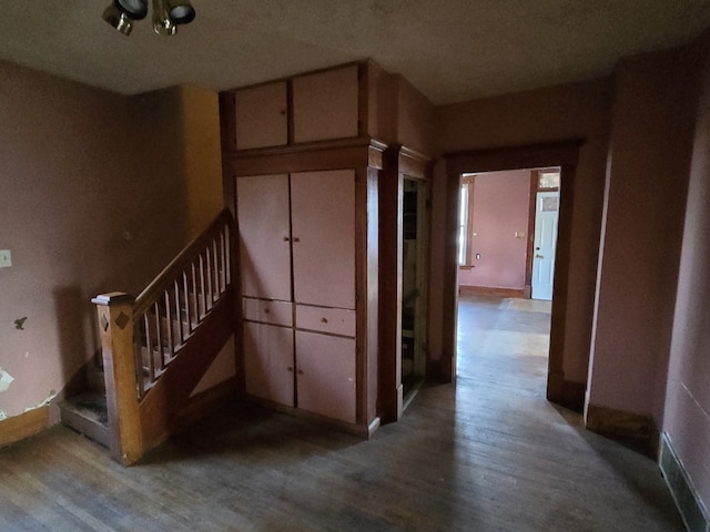 corridor with hardwood / wood-style flooring