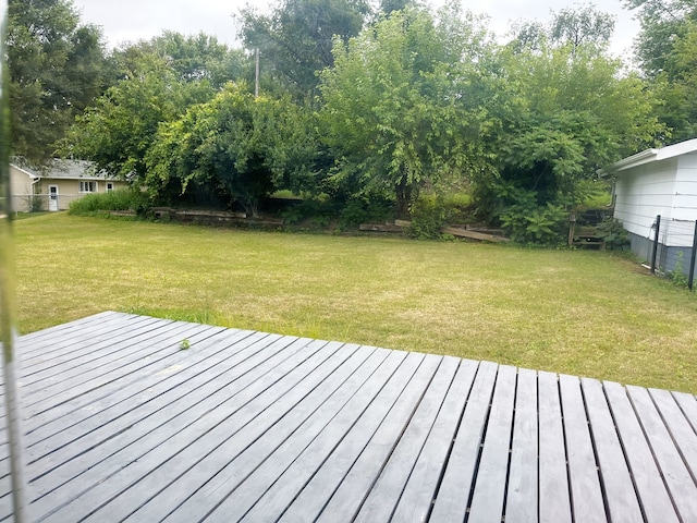 wooden deck featuring a lawn