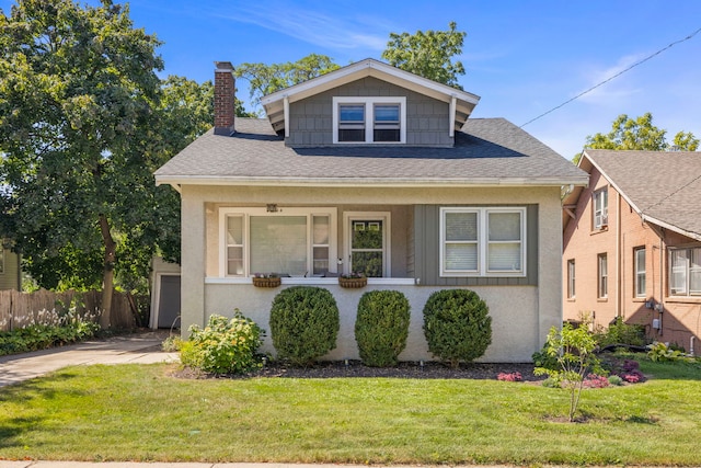 bungalow-style house with fence, a porch, concrete driveway, roof with shingles, and a front yard