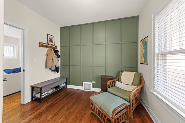 living area featuring dark wood-type flooring, baseboards, and visible vents