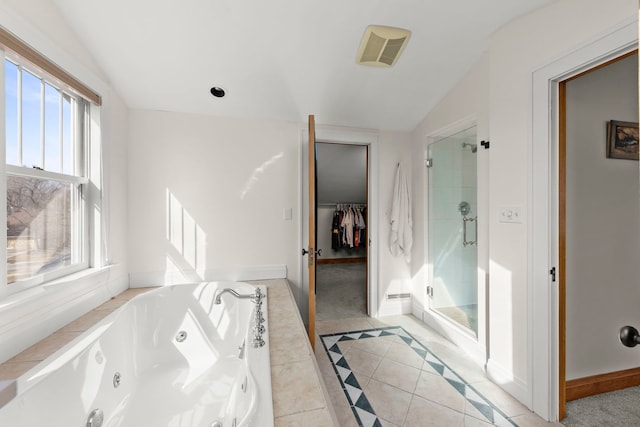 full bath with a spacious closet, a jetted tub, baseboards, vaulted ceiling, and a stall shower