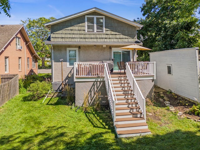 rear view of house featuring stucco siding, central AC, fence, a yard, and stairs