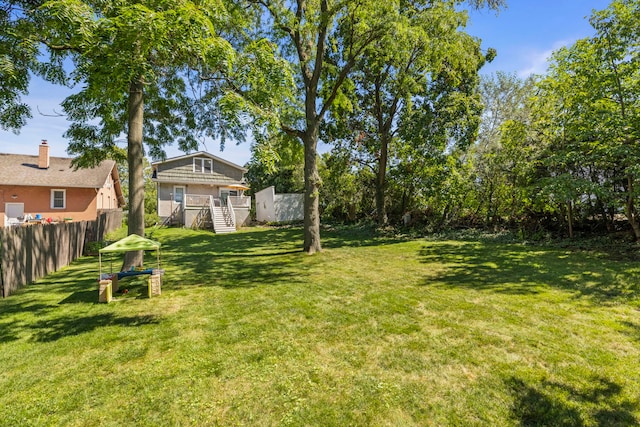 view of yard featuring fence and a wooden deck