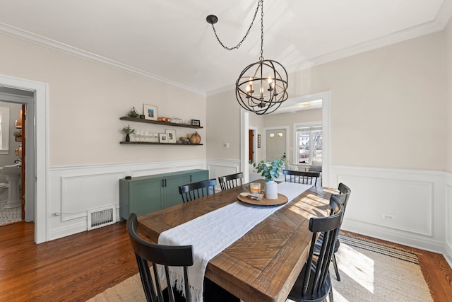 dining room featuring visible vents, an inviting chandelier, wood finished floors, and wainscoting