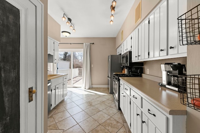 kitchen with white cabinetry, appliances with stainless steel finishes, light tile patterned flooring, rail lighting, and light countertops