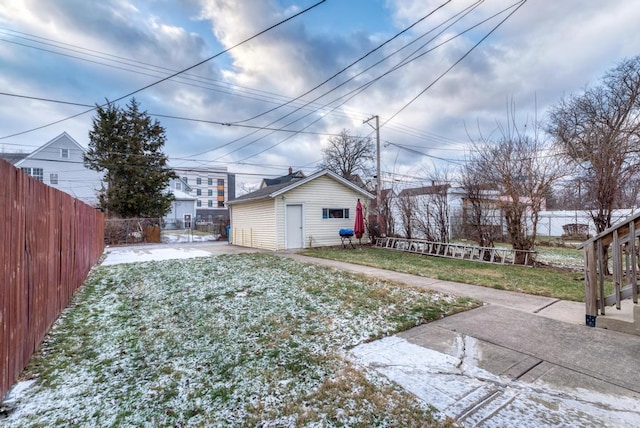 yard covered in snow featuring a patio area and an outdoor structure