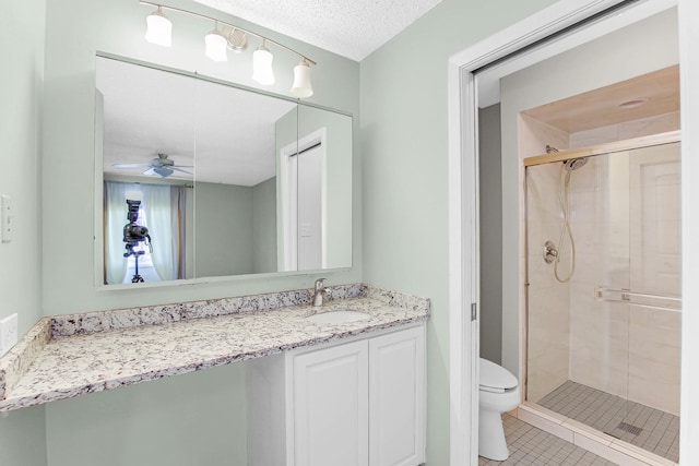 bathroom featuring ceiling fan, walk in shower, a textured ceiling, toilet, and vanity