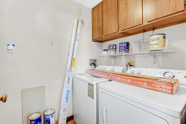 washroom featuring cabinets and washer and clothes dryer