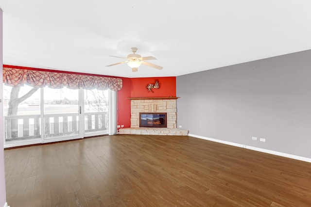 unfurnished living room featuring wood-type flooring, a stone fireplace, and ceiling fan