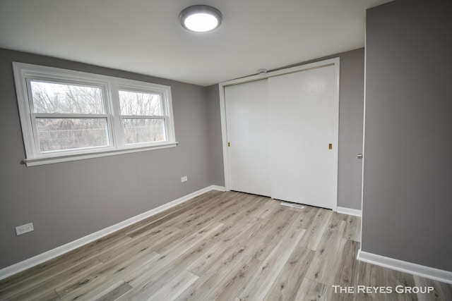 unfurnished bedroom featuring light hardwood / wood-style flooring and a closet