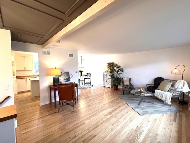 living area featuring light hardwood / wood-style flooring and beam ceiling