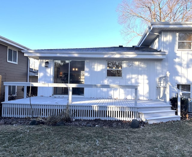 rear view of house with a lawn and a deck