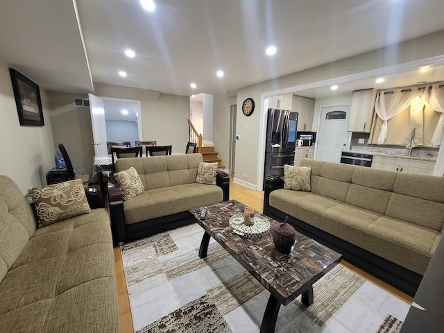 living room with light hardwood / wood-style flooring and sink