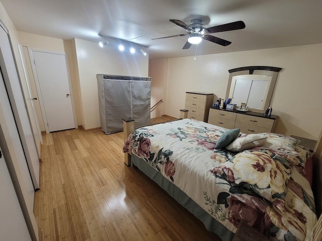 bedroom featuring ceiling fan, light hardwood / wood-style flooring, and track lighting