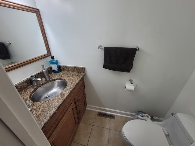 bathroom with tile patterned flooring, vanity, and toilet