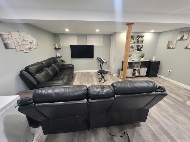 living room featuring light wood-type flooring and decorative columns