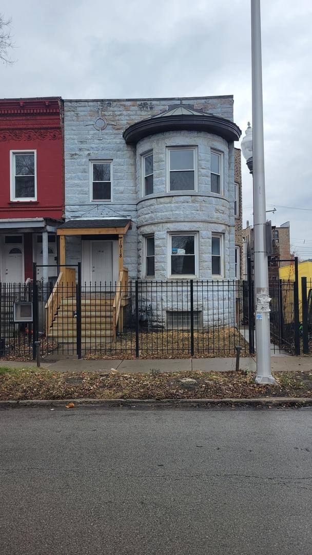 1918 S Kedzie Ave, Chicago, IL 60623 - view of front of property with stone siding and a fenced front yard