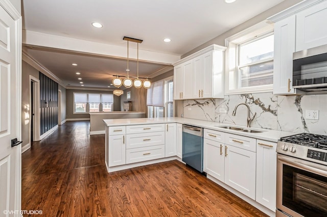 kitchen with pendant lighting, decorative backsplash, kitchen peninsula, and stainless steel appliances