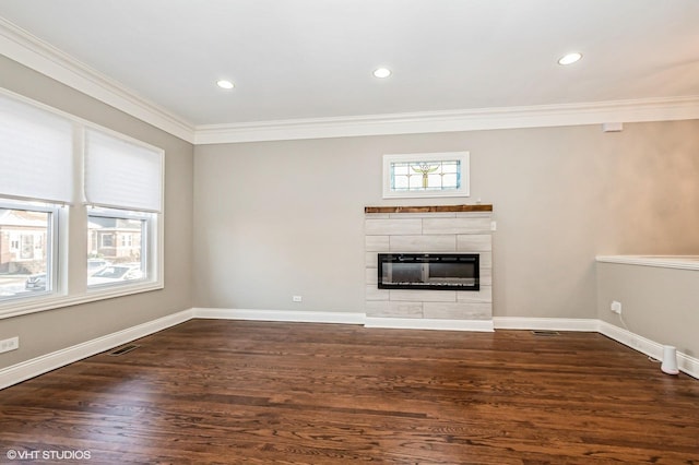 unfurnished living room featuring a tile fireplace, crown molding, and dark hardwood / wood-style floors