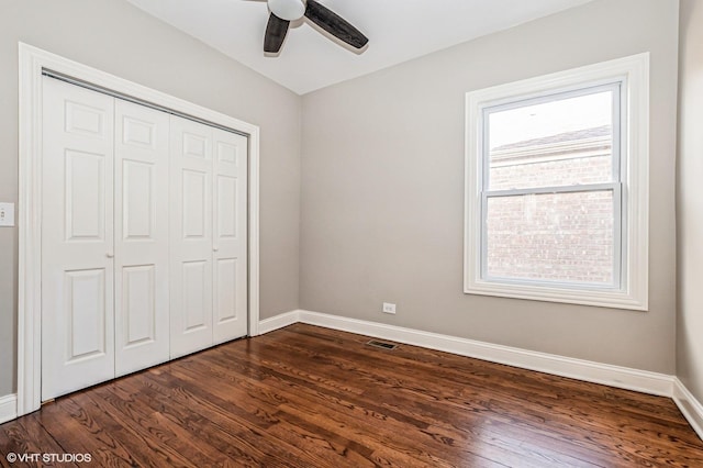 unfurnished bedroom featuring ceiling fan, dark hardwood / wood-style floors, and a closet