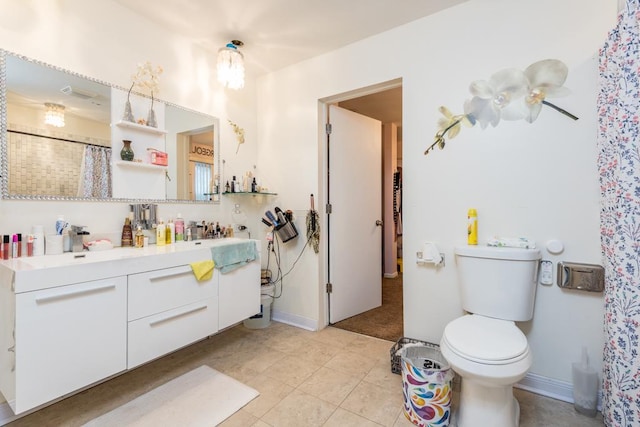 bathroom with tile patterned flooring, vanity, and toilet