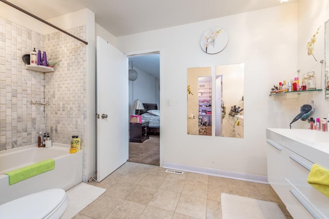 full bathroom featuring vanity, tiled shower / bath combo, and toilet