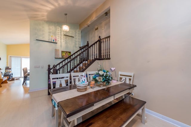 dining space with hardwood / wood-style floors and an inviting chandelier