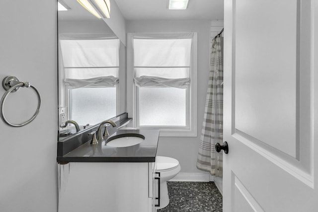 bathroom featuring toilet, a shower with shower curtain, and vanity