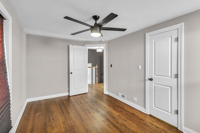 unfurnished bedroom featuring dark wood-type flooring and ceiling fan