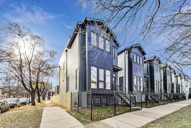 view of side of home featuring a fenced front yard and a residential view