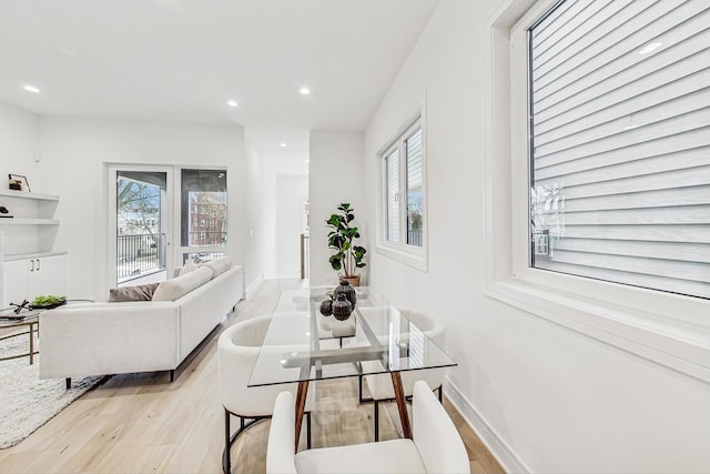 living area featuring plenty of natural light, light wood-type flooring, baseboards, and recessed lighting